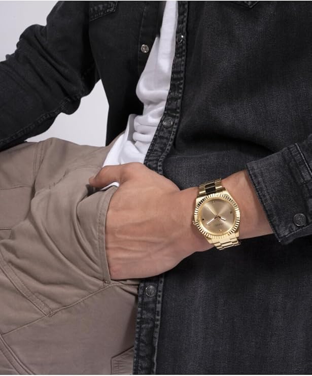 Guess Connoisseur gold watch worn on wrist with casual styling