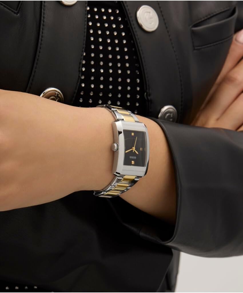 Square watch on wrist displaying black face and two-tone metal bracelet