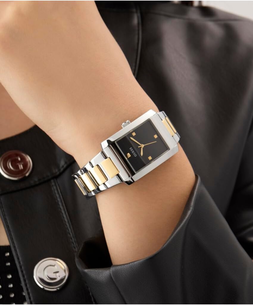 GUESS square watch worn on wrist showing black dial with gold accents