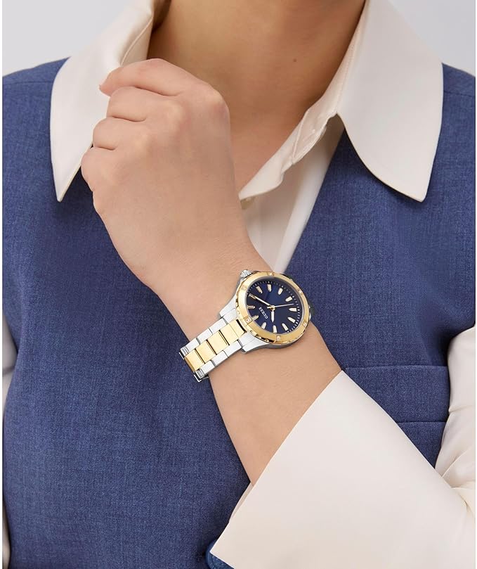 Guess Mist watch worn on wrist, showing blue dial and two-tone gold and silver bracelet